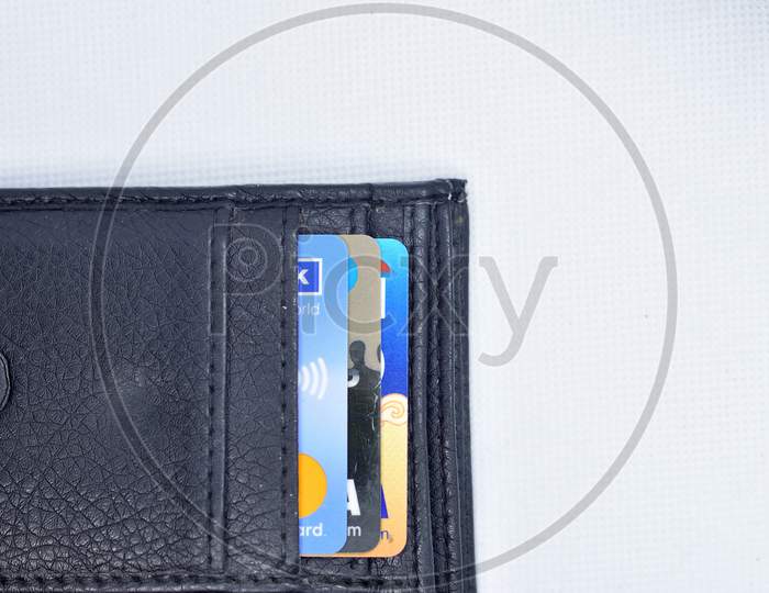 Debit And Credit Cards In Black Color Wallet On White Background. Top View.