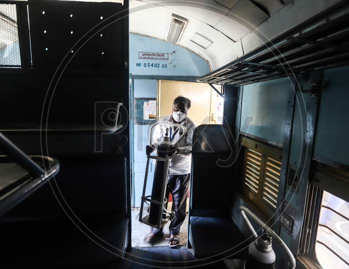 Workers Fix An Oxygen Cylinder Inside A Train Coach As A Temporary Covid-19 Isolation Facility At Anand Vihar Railway Station, In New Delhi On June 17, 2020.