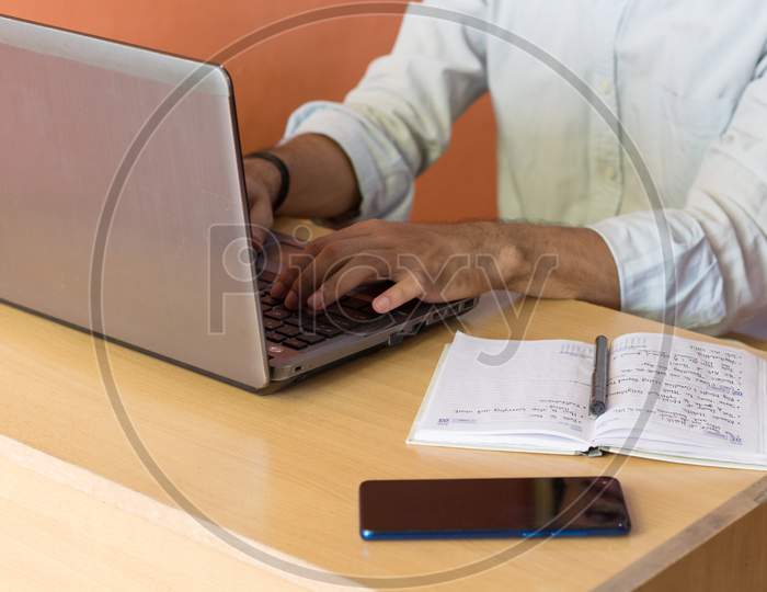 A Young Adult Working From Home On A Laptop