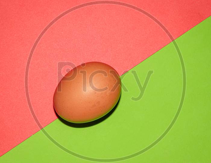 Brown colour  egg on red green  two colour background . Top view.