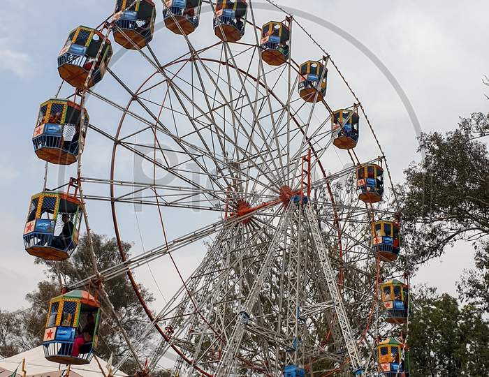 Mandi, Himachal Pradesh / India - February 28 2020: Photo of amazing colorful observation wheel in festival fair of India with selective focus, selective focus on subject, background blur
