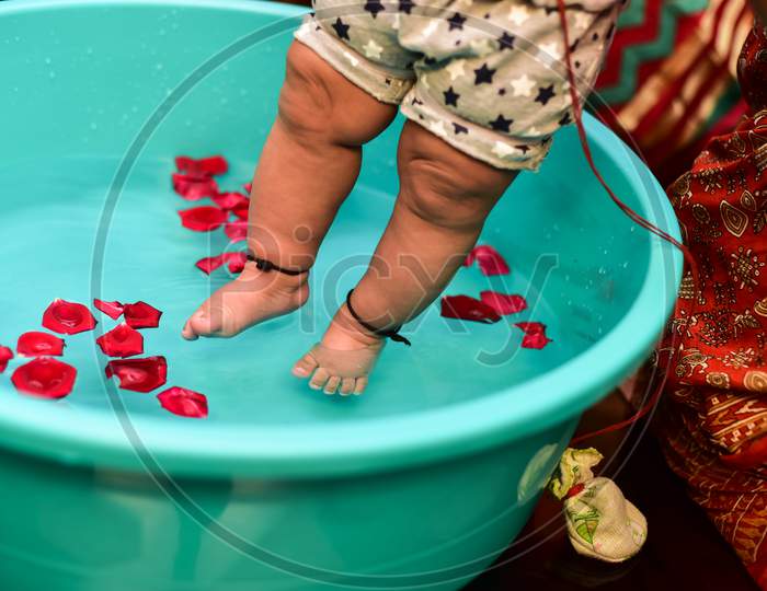 Legs of a newborn in closeup. Baby's feet and copy space. Infant care and colic. Playing in water.