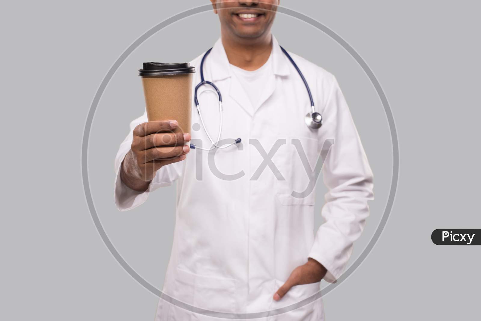 Doctor Holding Coffee Take Away Cup Smiling Isolated. Indian Man Doctor Holding Coffee To Go Cup.