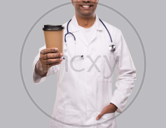 Doctor Holding Coffee Take Away Cup Smiling Isolated. Indian Man Doctor Holding Coffee To Go Cup.