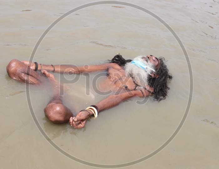A Sadhu Performs Yoga In the river Ganga, on The Occasion Of International Yoga Day In Prayagraj, June 21, 2020.