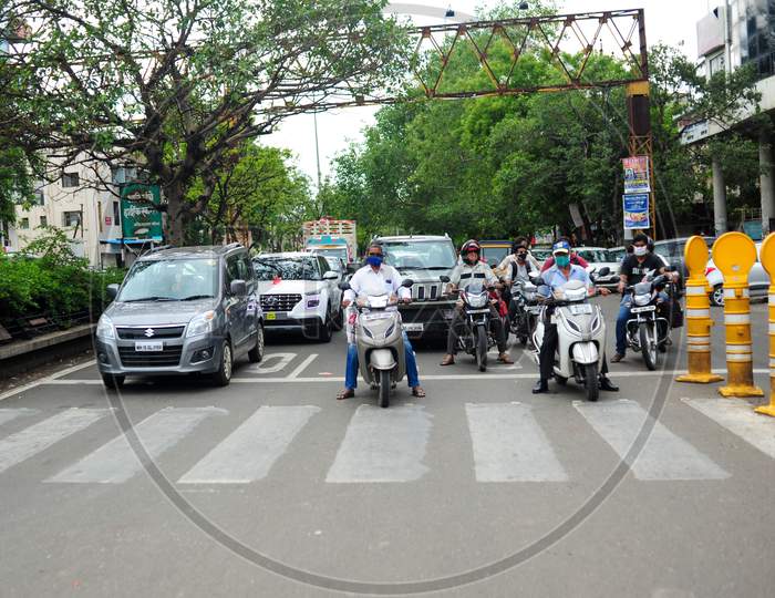Motorists standing at the traffic signal wearing masks