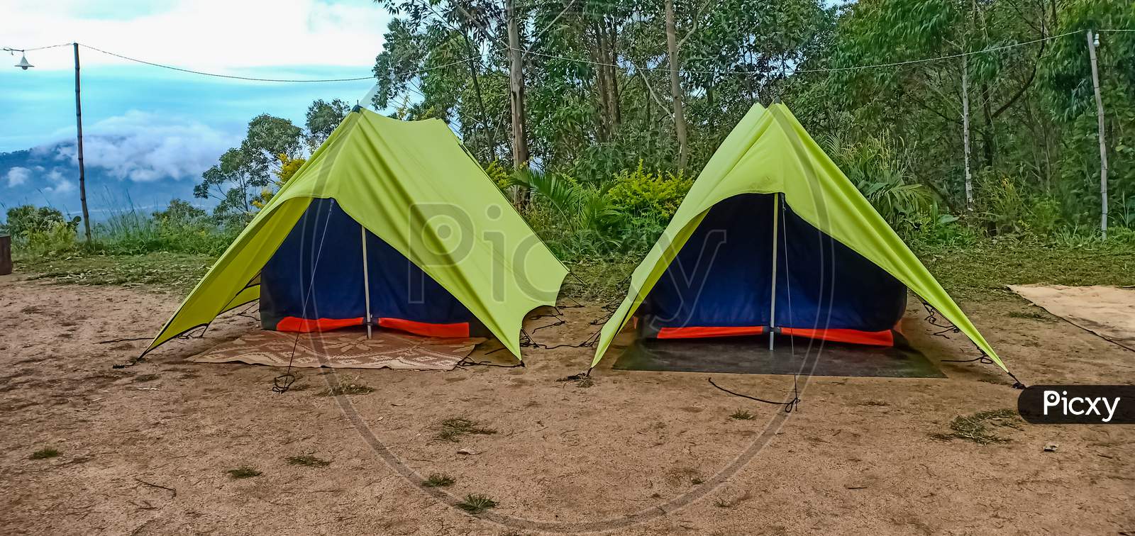 Triangle Tent Camping Near Mountain Forest. Camping Tent In The Top Of Mountain In The Morning Background Forest