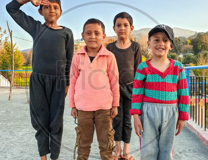Mandi, Himachal Pradesh / India - February 15 2020: Photo of naughty group of Indian children with wearing colorful clothes, looking to camera with selective focus, selective focus on subject, background blur