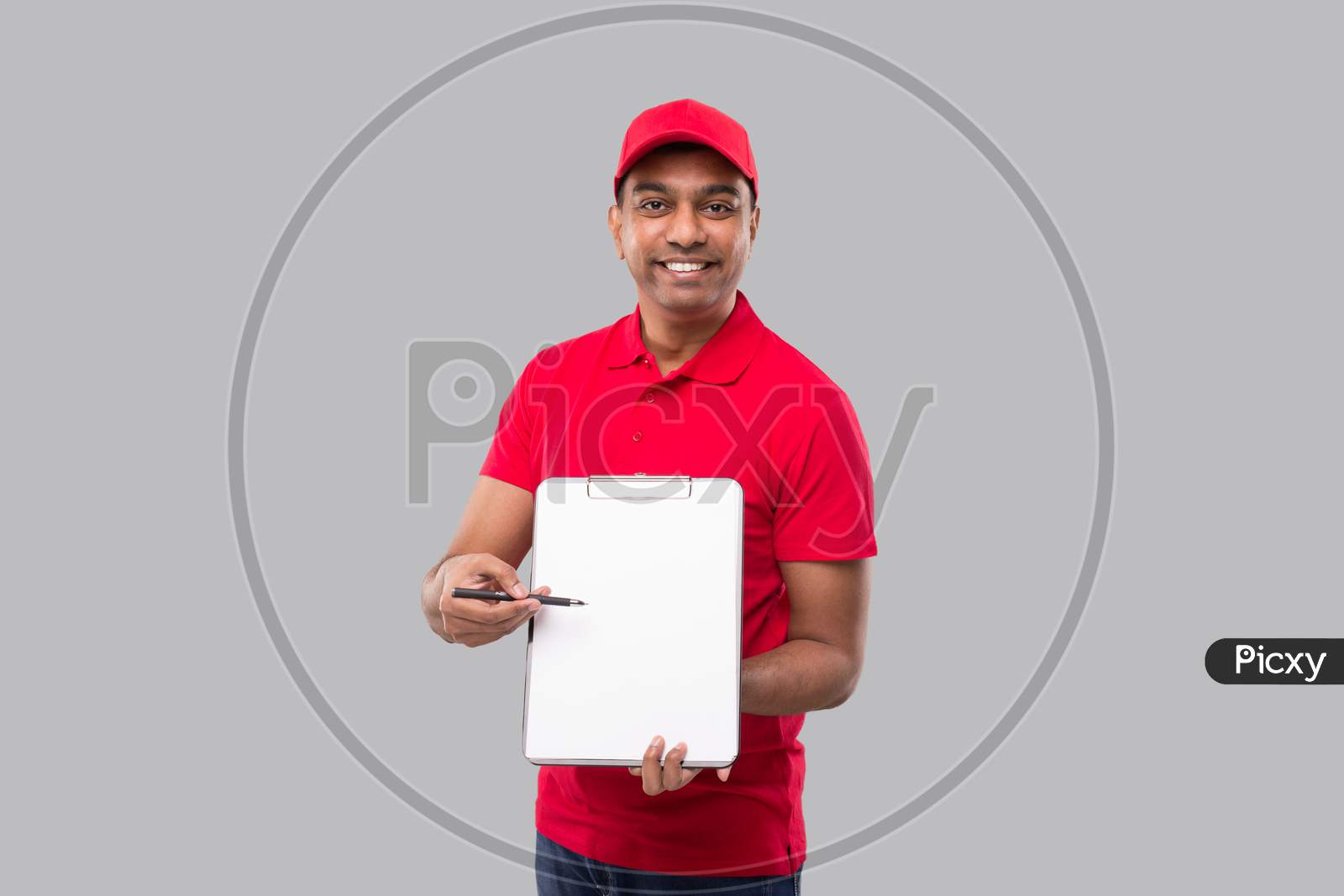 Delivery Man Pointing At Clipboard Watching In Camera. Indian Delivery Boy Clipboard