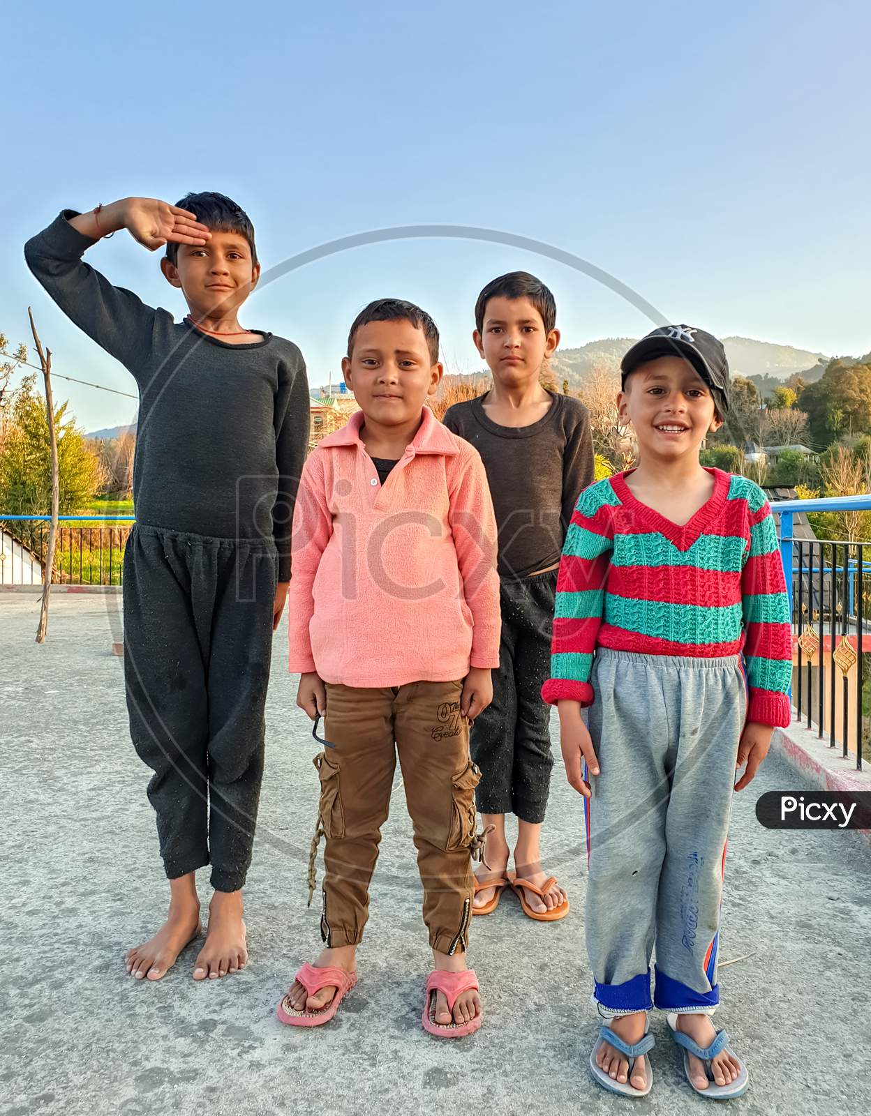 Mandi, Himachal Pradesh / India - February 15 2020: Photo of naughty group of Indian children with wearing colorful clothes, looking to camera with selective focus, selective focus on subject, background blur