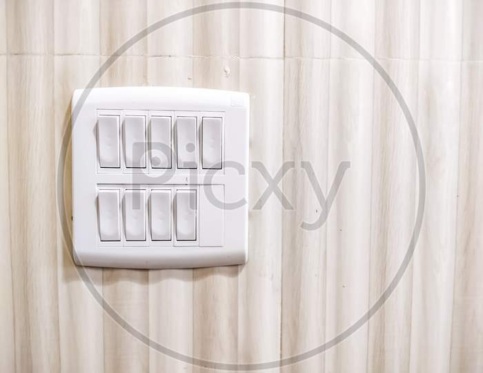 White Light switch on switchboard - Light brown background