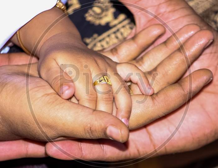 Baby Hand. Closeup Of Baby Hand Into Parents Hands. Family Baby Hands. Father And Mother Holding Newborn Kid. Child Hand Closeup Into Parents. Mom And Dad Hold Baby'S Hand.