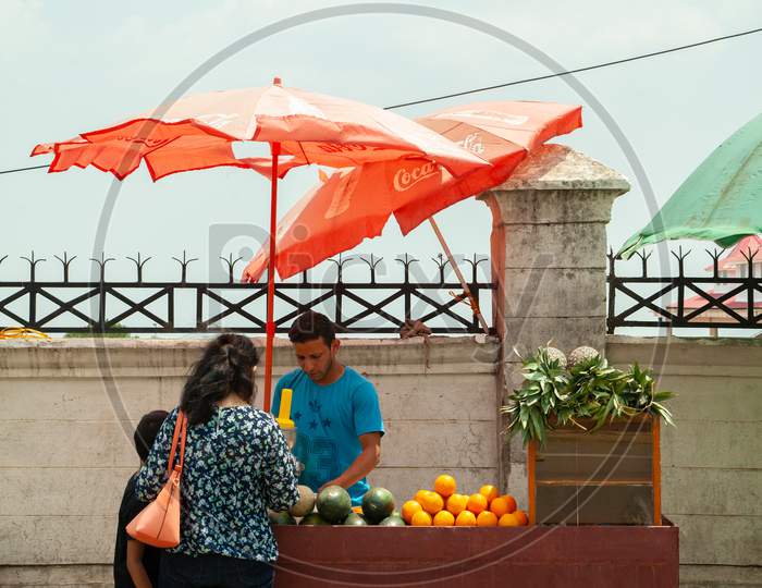 Customer Is Buying Orange Juice From Juice Vendor