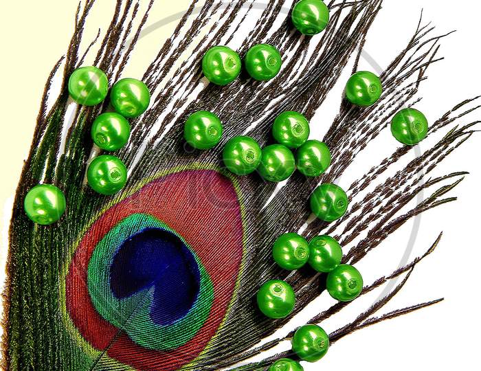 Decoration with peacock feather and green plastic balls