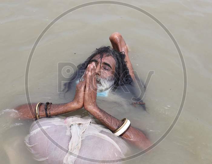 A Sadhu Performs Yoga In the river Ganga, on The Occasion Of International Yoga Day In Prayagraj, June 21, 2020.