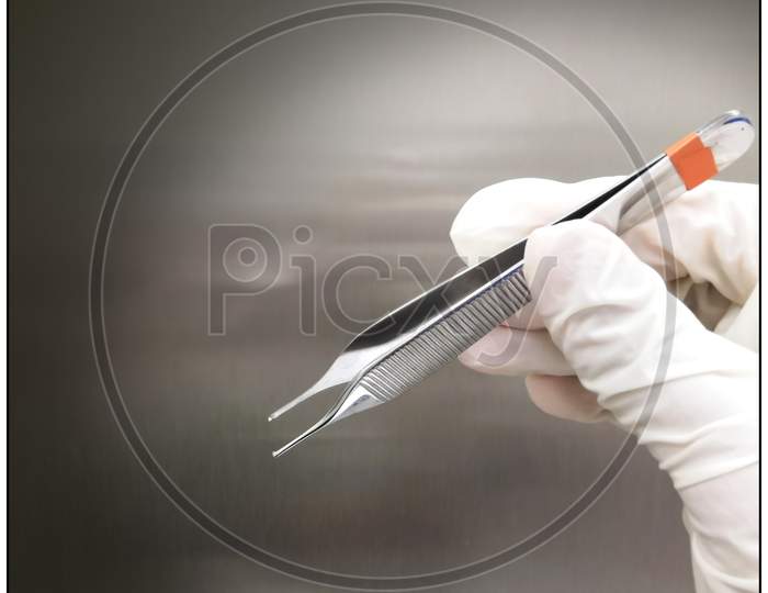 Surgeon Holding Adson Tissue Forceps