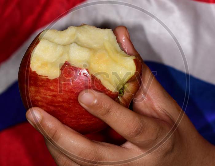 Hand holding a half eaten fresh apple