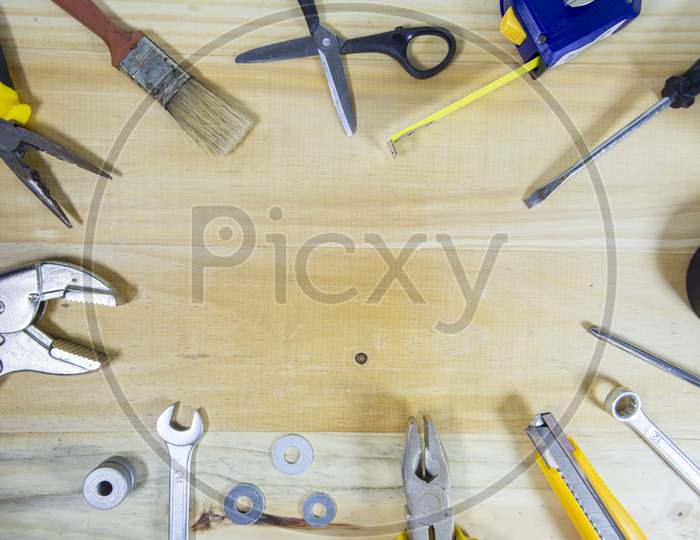 Working Instruments Scattered On A Wooden Surface With Space For Text In The Center