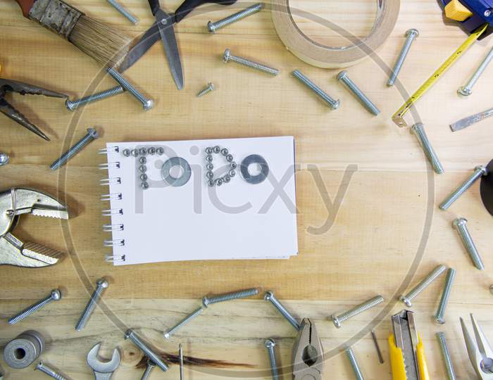 The Phrase "To Do" Made Of Screws On A Notebook Surrounded By Instruments Wooden Surface For Planning The Work.