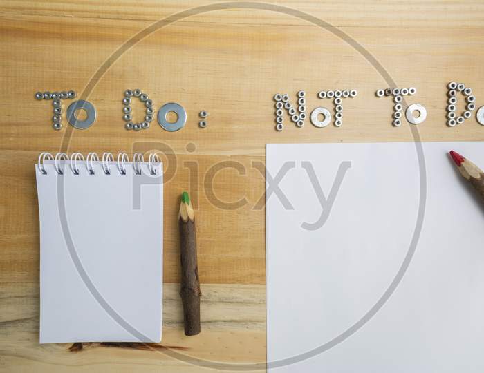 Top View Of The Phrases "To Do" And "Not To Do" Made Of Nuts And Washers On A Wooden Surface For Planning The Work.