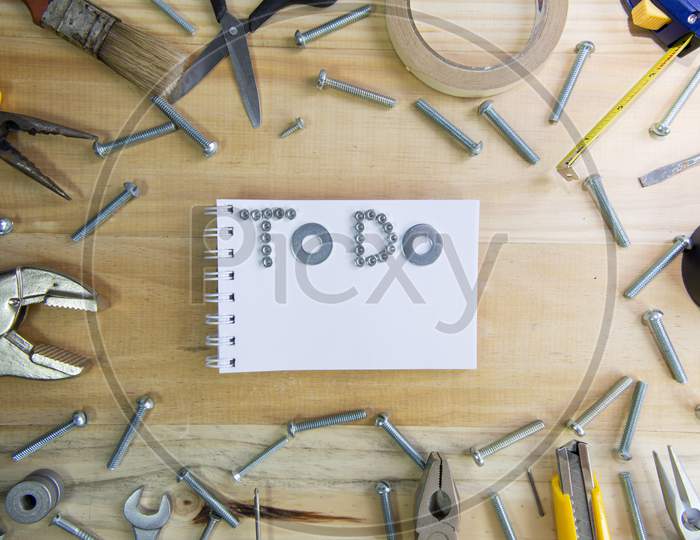 The Phrase "To Do" Made Of Screws On A Notebook Surrounded By Instruments Wooden Surface For Planning The Work