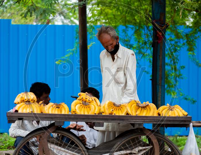 Old man selling fruits on the street.