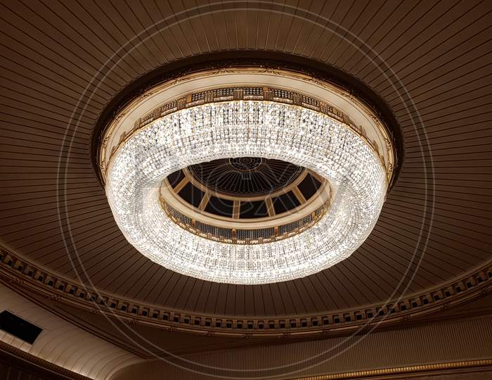 A Huge Chandelier Hangs From The Ceiling. Decorated With Glass For Greater Light Output.