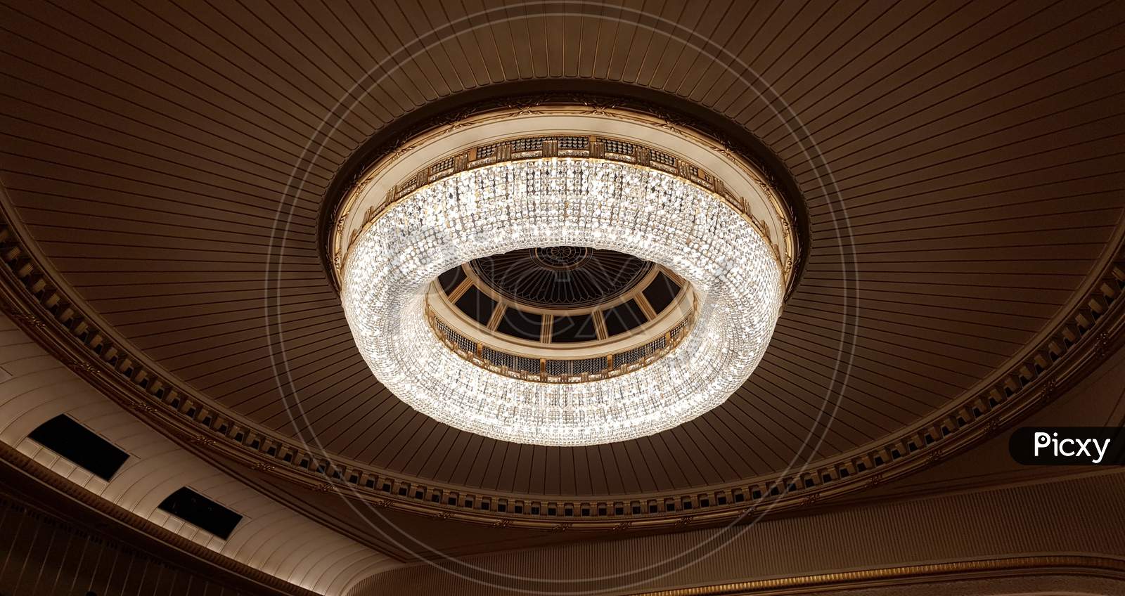 A Huge Chandelier Hangs From The Ceiling. Decorated With Glass For Greater Light Output.