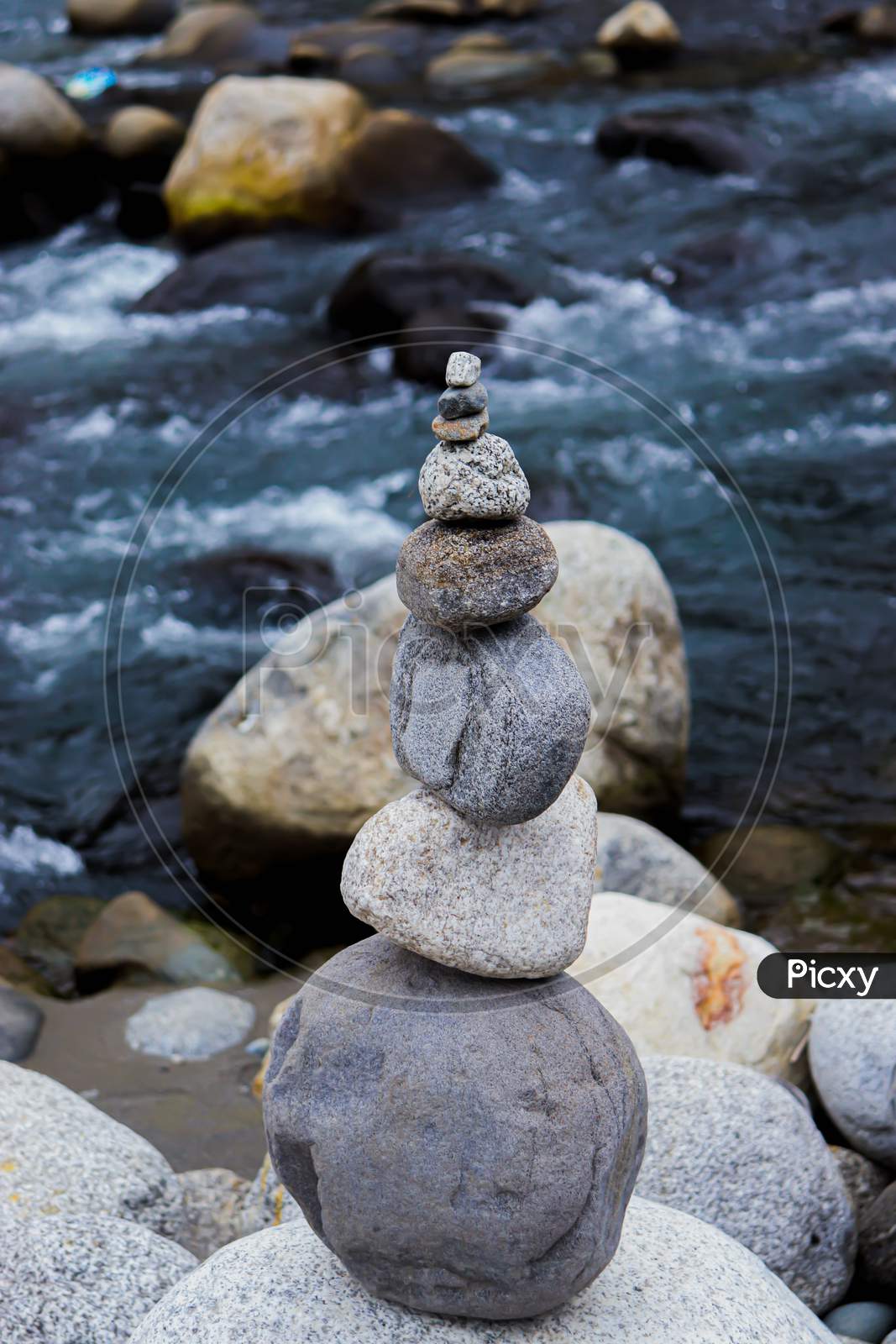 Rock Balancing Having Flowing River In The Background