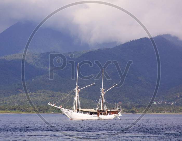 White Sail Boat In Calm Tropical Seas Navigation