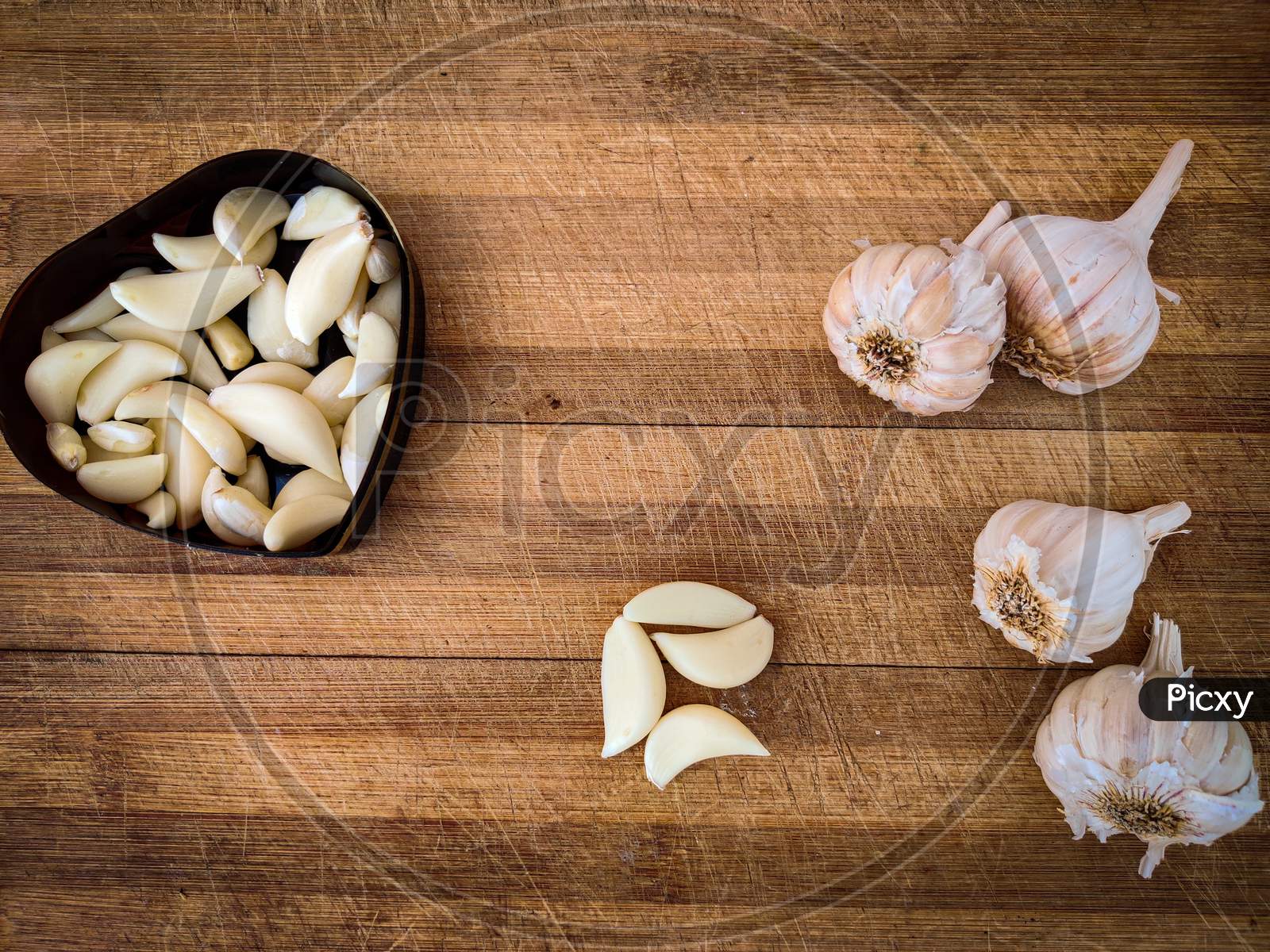 Garlic Cloves Kept In Wooden Chopping Board,Daylight