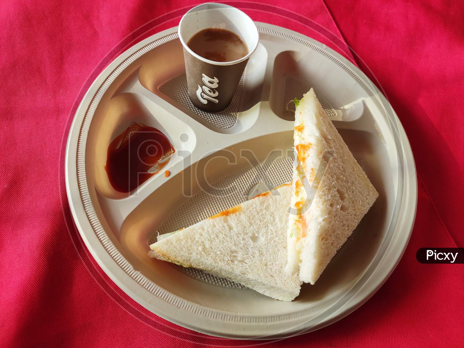 Sandwiches with tomato sauce and a cup of tea in the plate in breakfast