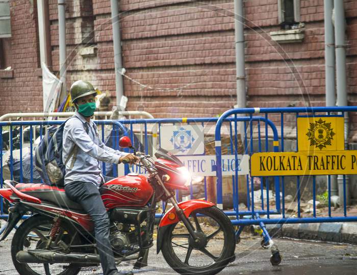 A Police person riding on a bike  while raining in kolkata near Lalbazar Police Headquarters on 21st June 2020 at Kolkata, West Bengal, India