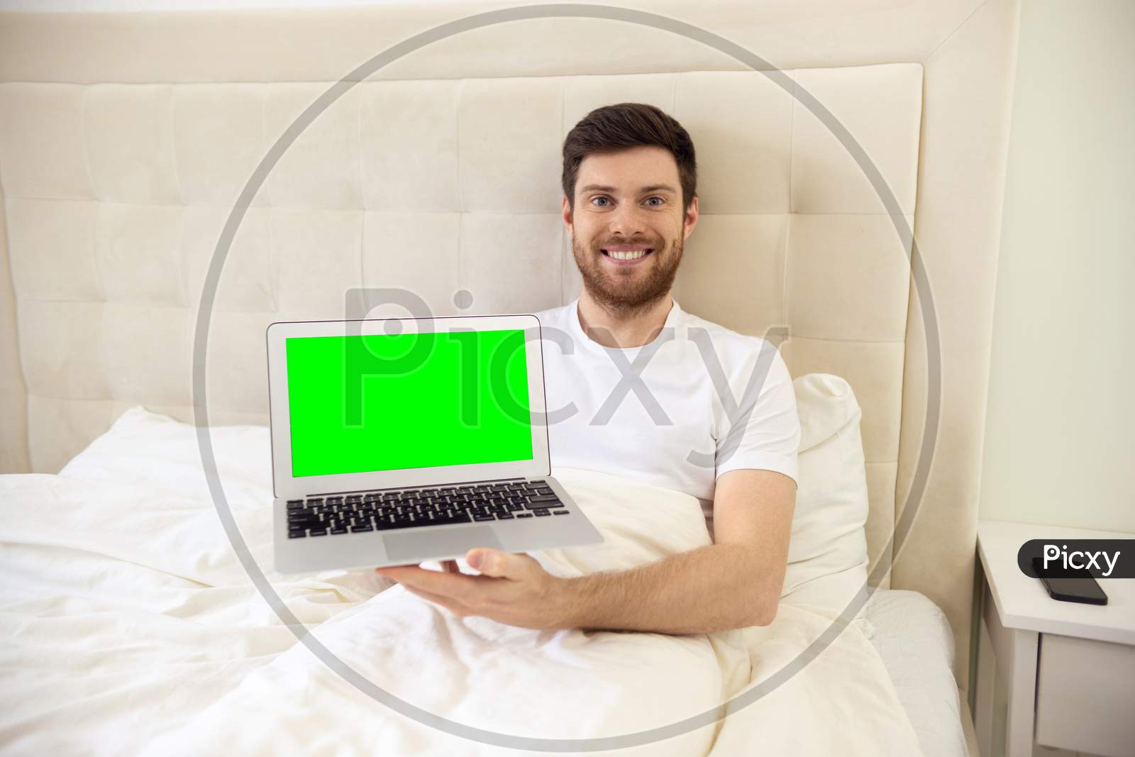 Man Showing Laptop Laying In Bed At Home. Good Morning Handsome Man Using Laptop.