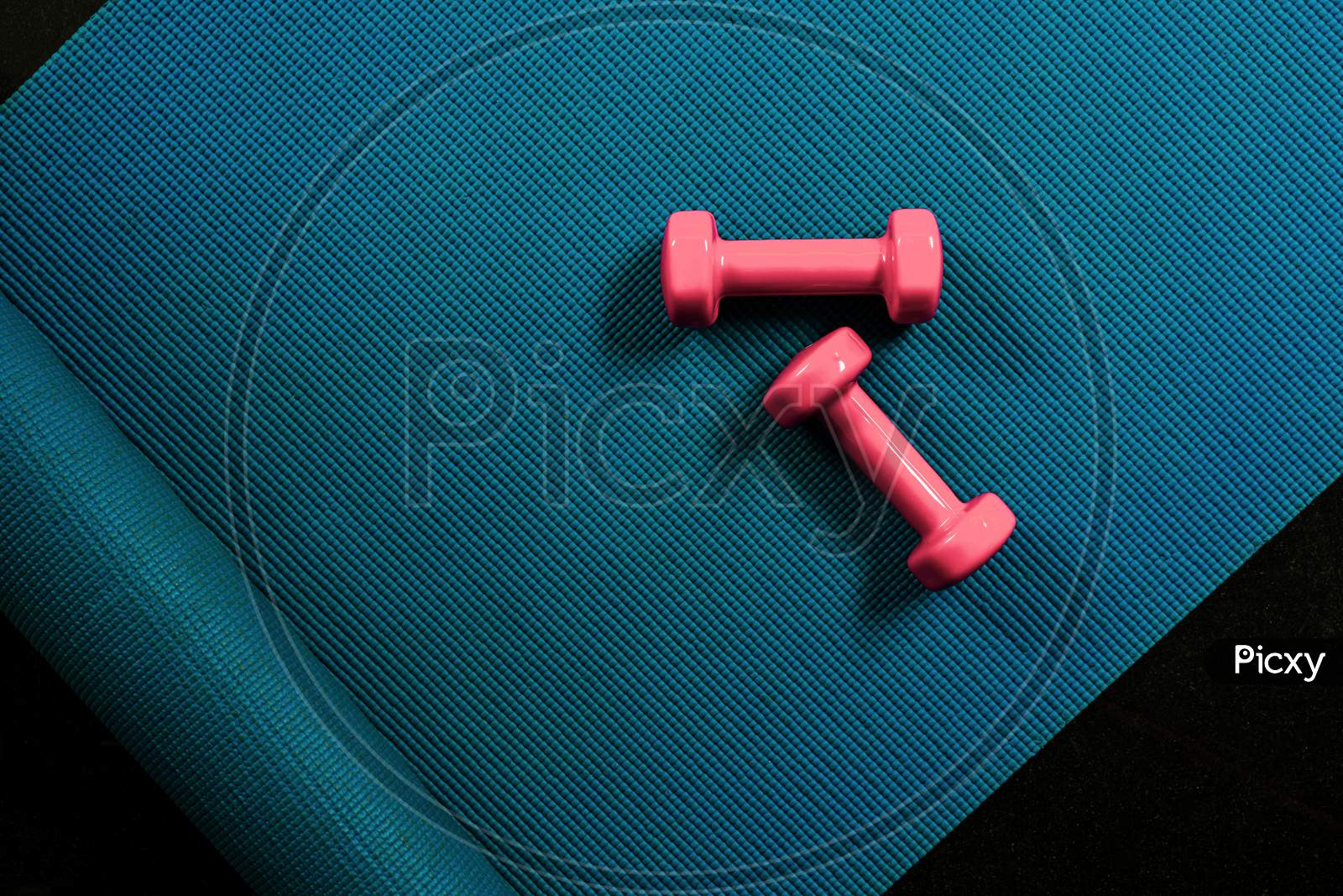 Top view of dumbbells on yoga mat. Fitness concept flat lay with copy space