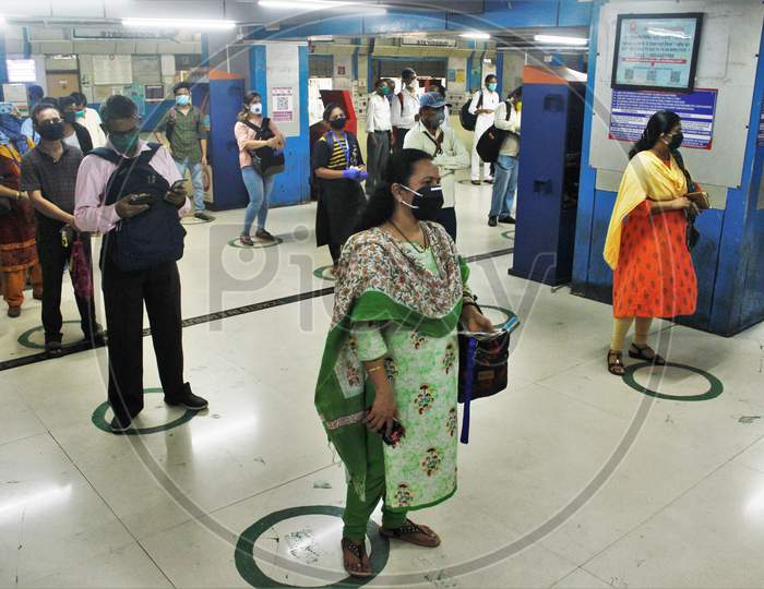 Commuters stand inside circles to maintain social distancing as they wait to buy local train tickets, after the government eased a nationwide lockdown that was imposed as a preventative measure against the COVID-19  coronavirus , at Churchgate station, in Mumbai, India on June 16, 2020.