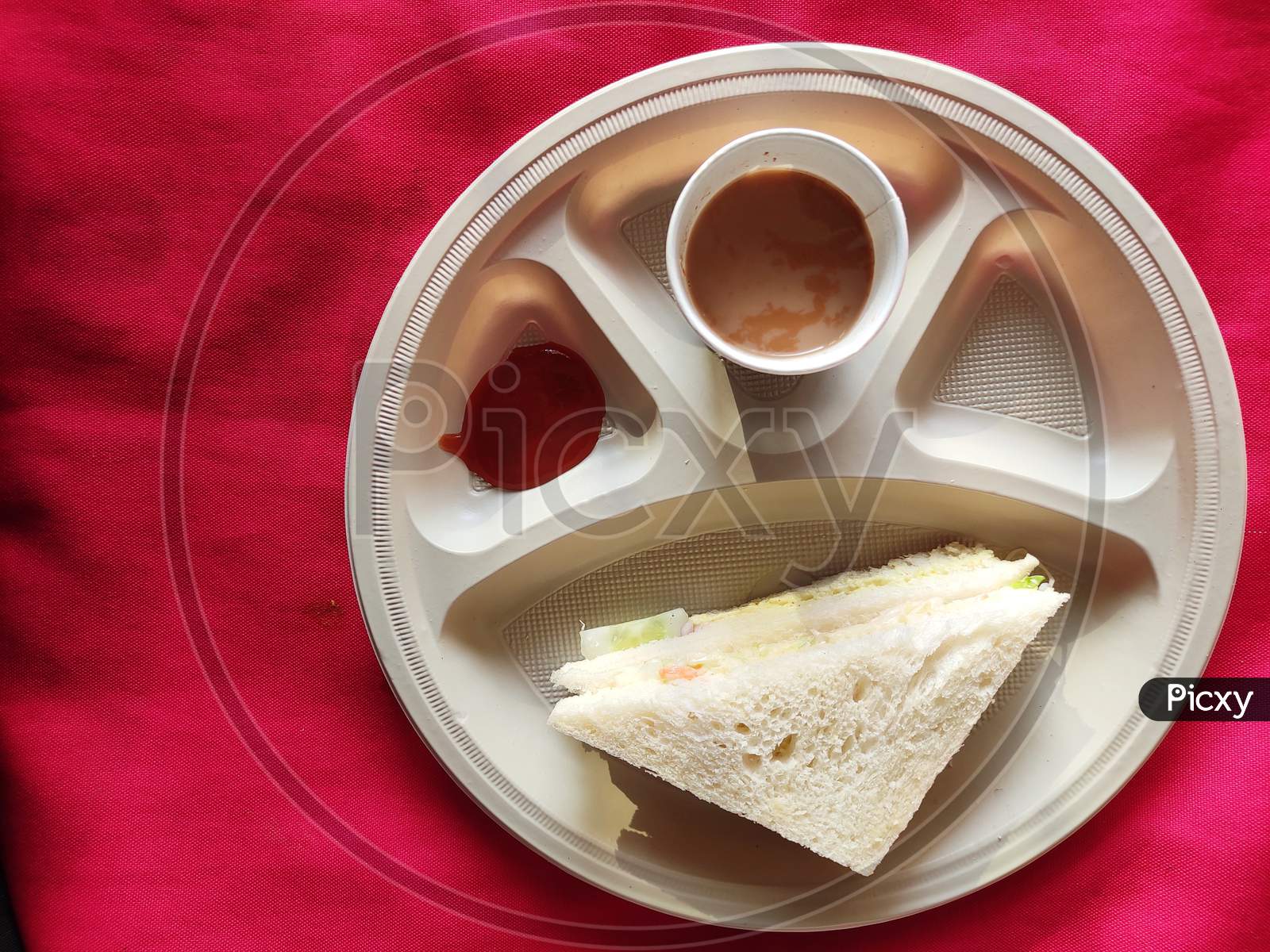 Top view: Sandwiches with tomato sauce and a cup of tea in the plate in breakfast