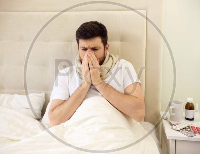 Man Sneezing In Bed. Sick Man At Home Staying In Bed. Treatment, Unhealthy