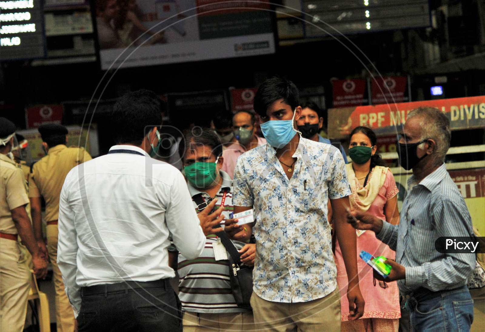A railway official checks the ID cards of the commuters before they board the trains, at Churchgate station, after the government eased a nationwide lockdown that was imposed as a preventive measure against the COVID-19 coronavirus, at Churchgate station, in Mumbai, India, on June 16, 2020.