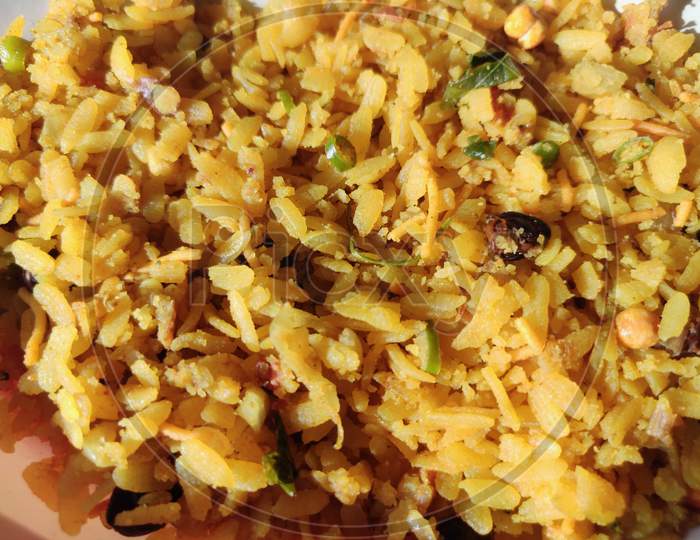 Closeup of poha or aalu poha or pohe made up of beaten rice or flattened rice, favourite indian snack taken with tea in plate