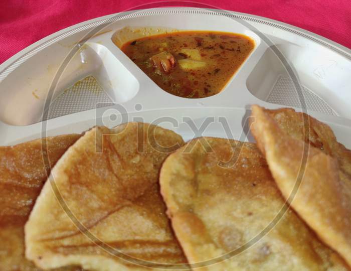 Puri and Potato Curry aalu sabji Close-up - an indian cuisine in round plate.