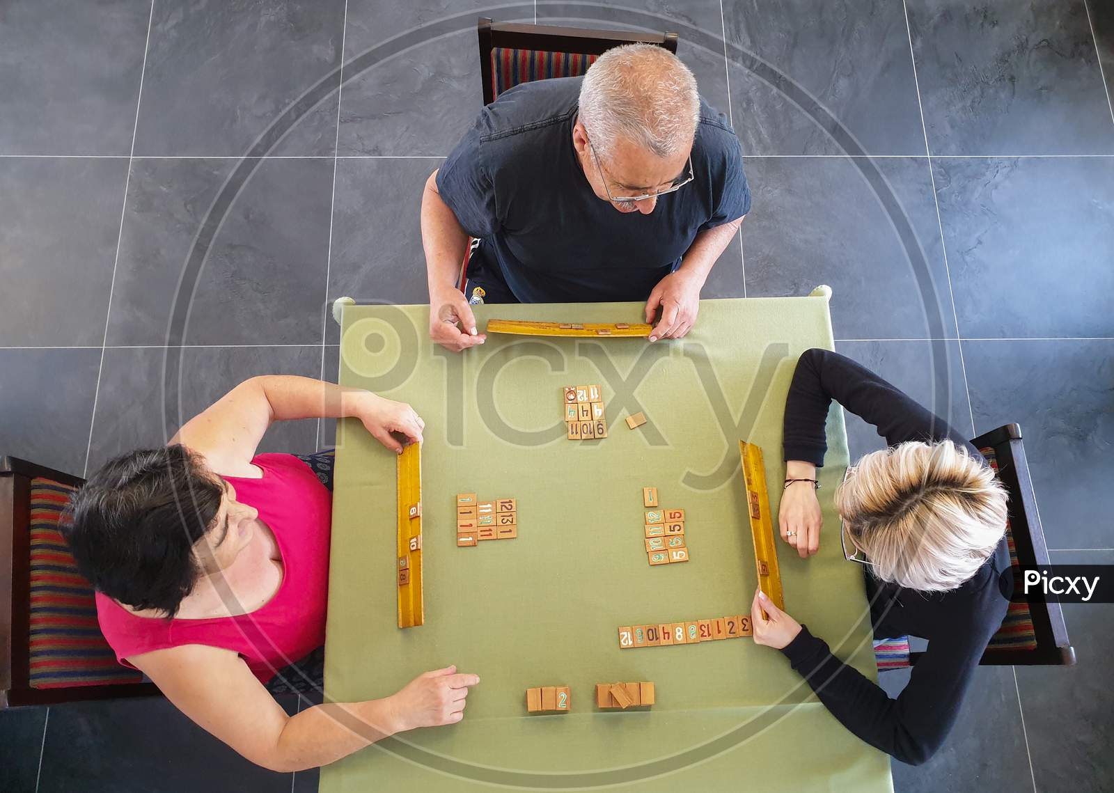 Family Of Three Playing Rummy Game Indoors