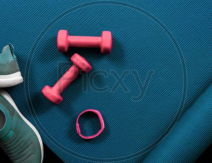 Image of Fitness flat lay with dumbbells, shoes, activity tracker and ...