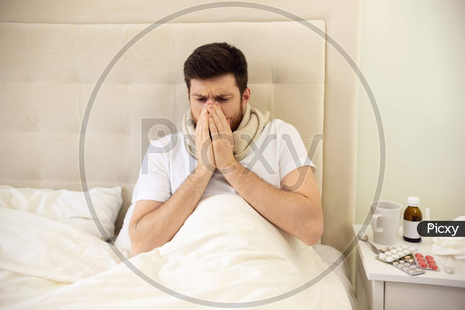 Man Sneezing In Bed. Sick Man At Home Staying In Bed. Treatment, Unhealthy
