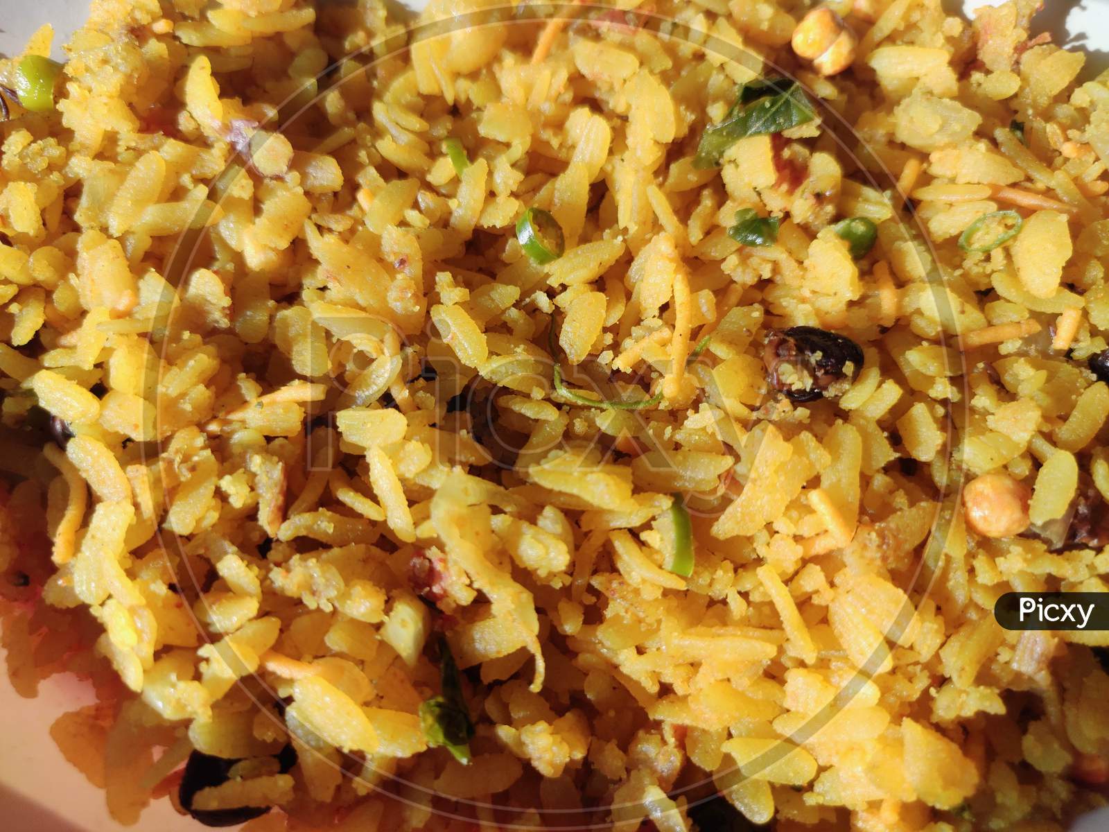 Closeup of poha or aalu poha or pohe made up of beaten rice or flattened rice, favourite indian snack taken with tea in plate