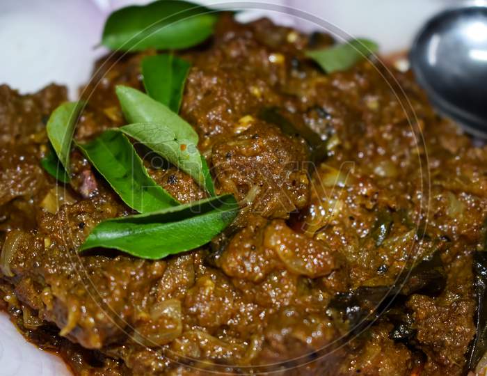 South Indian Cuisine Kerala Style Beef Fry / Roast. Traditional Style Meat Roast. Garnished With Onion Slices And Curry Leaves. Selective Focus Photograph.