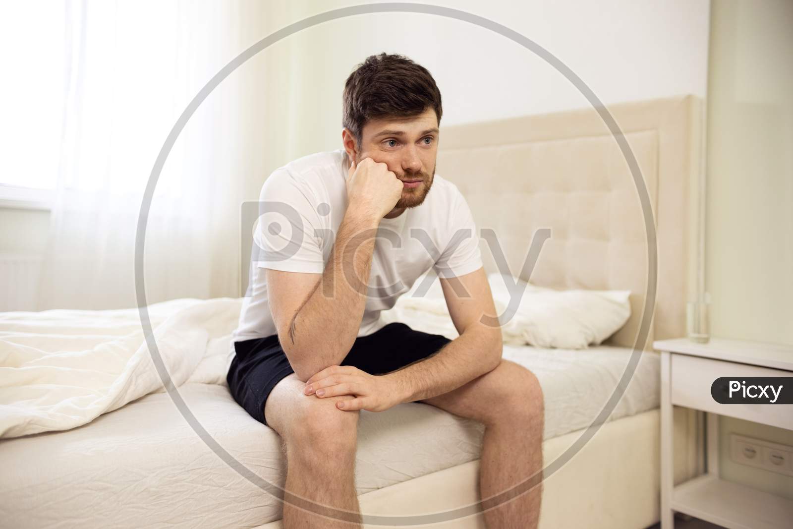Man Sitting On Bed Tired. Disappointed Man At Home. Lonely Bored Man In Bed