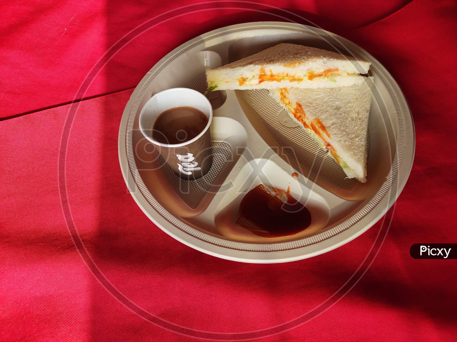 Sandwiches with tomato sauce and a cup of tea in the plate in breakfast