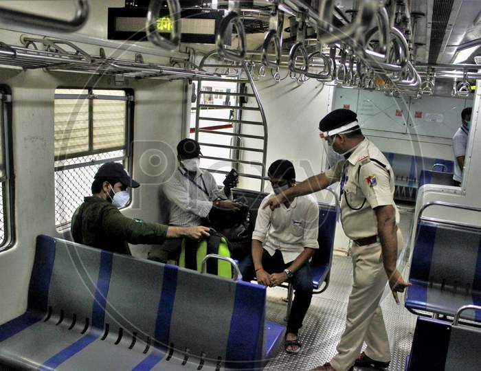 Police personnel instruct the commuters to maintain social distance inside the train, after the government eased a nationwide lockdown that was imposed as a preventive measure against the COVID-19 coronavirus, at Churchgate station, in Mumbai, India, on June 16, 2020.