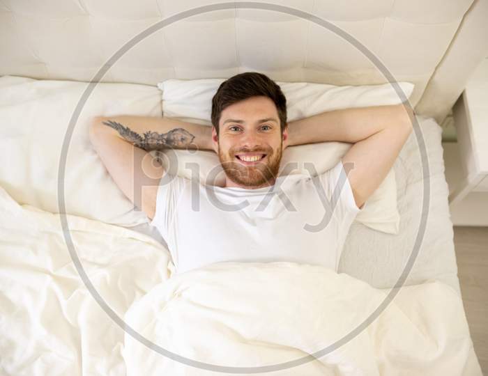 Handsome Man Laying In Bed Smilling. Morning At Home. Up Down Shoot. Man Portrait In Bed Watching In Camera.